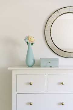 Flower vase and jewelry box on cabinet