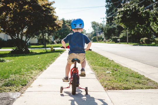 Young child riding a bike with training wheels