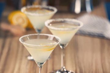 Glasses with tasty lemon drop martini cocktail on table, closeup