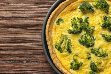 Tasty broccoli quiche on wooden table