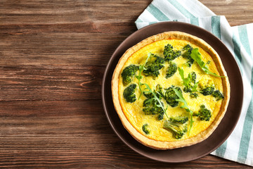 Tasty broccoli quiche on wooden table