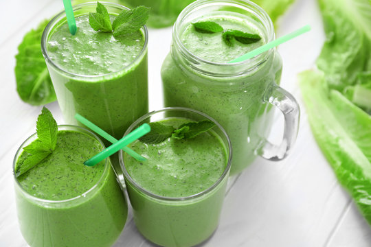 Healthy smoothie with kale in glasses on wooden table