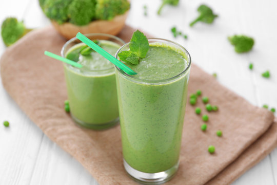 Healthy smoothie with kale in glasses on table