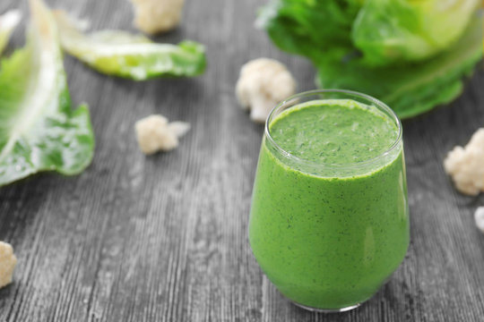 Healthy smoothie with kale in glass on wooden table