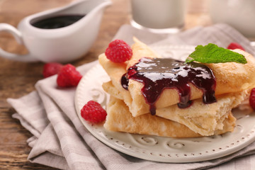 Delicious pancakes with raspberry jam on table