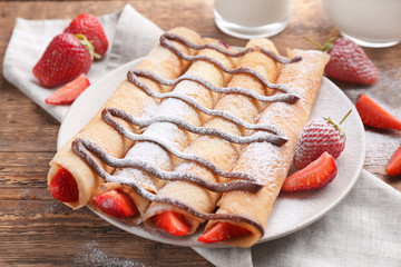 Delicious pancakes with chocolate and strawberry on plate