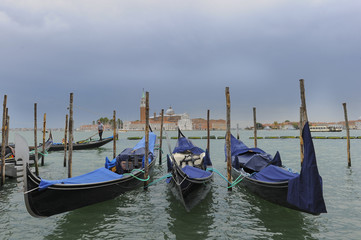 Fototapeta premium Traditional gondolas in the sea water on background of ancient Venice, Italy