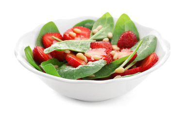 Plate of salad with spinach, strawberry and pine nuts on white background