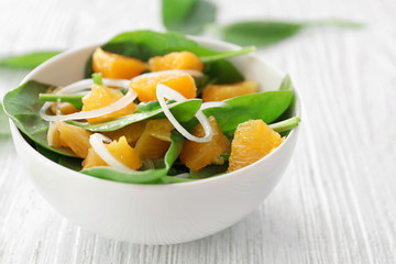 Plate of salad with spinach and orange  on table