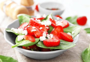 Plate of salad with spinach, strawberry and cottage cheese on table