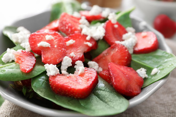 Plate of salad with spinach, strawberry and cottage cheese on table, closeup