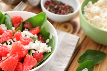 Plate of salad with spinach, grapefruit and cottage cheese on table