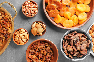 Dried apricots, raisins and nuts in different dishes on table