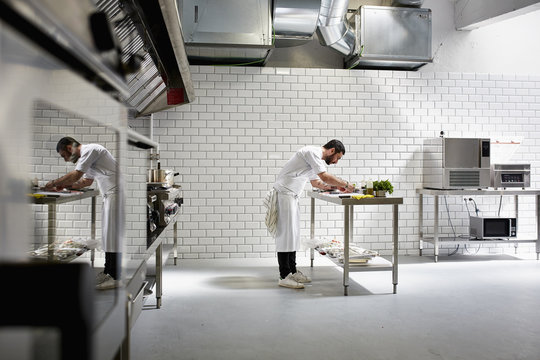 Male Chef Cooking In Commercial Kitchen