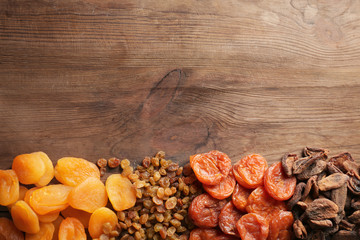 Dried apricots and raisins on wooden background