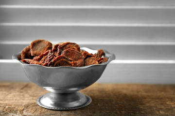Dried apricots in bowl on wooden table
