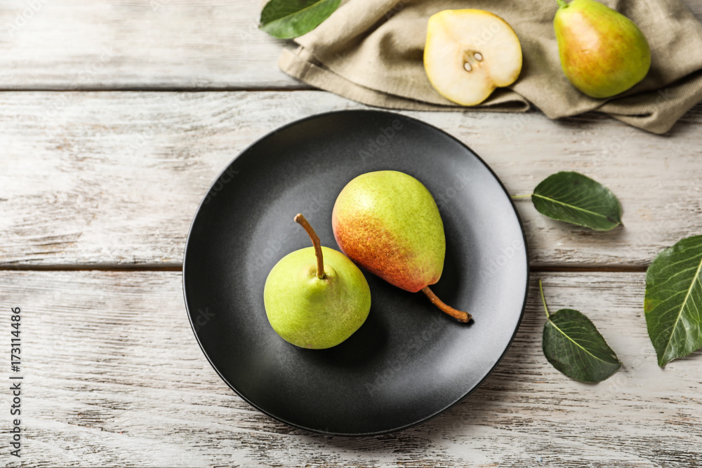 Wall mural ripe pears on black plate