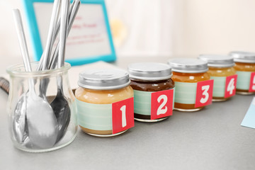 Jars with different puree on table. Game "Guess taste" for baby shower party