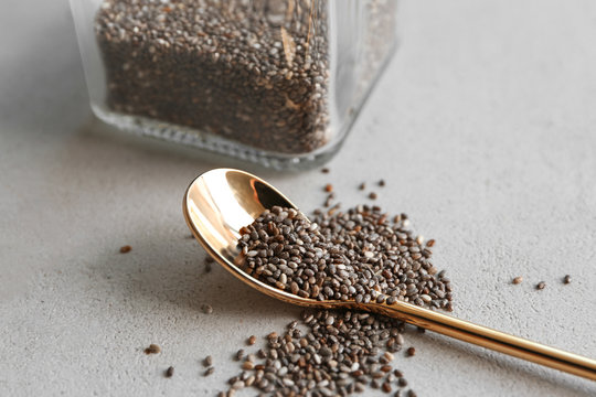 Chia seeds and spoon on light background