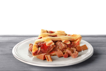 Plate with piece of tasty strawberry rhubarb pie on table