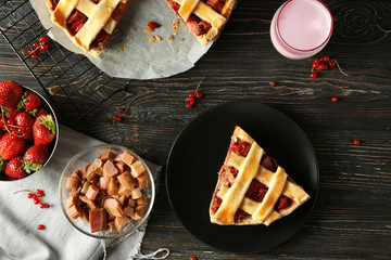 Composition with piece of delicious strawberry rhubarb pie on table