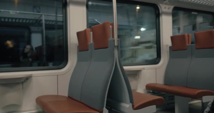 HELSINKI, FINLAND - JANUARY 07, 2017: Commuter train carriage with empty seats and family reflection in the window with following view to the boy passenger in winter overclothes (with model release)