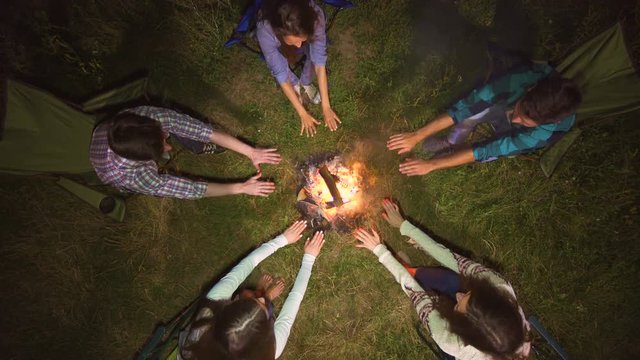 The five people warming near the bonfire. evening night time, view from above