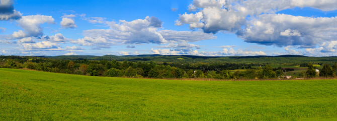 Hudson Valley skyline with farm land and meadows on a cloud filled summer day.