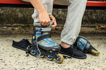 Woman putting on roller skates outdoor.
