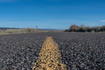 Low Angle View of Yellow Stripe on Rough Desert Road