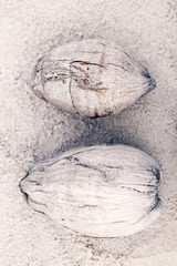 two coconuts on sand at the beach. top view