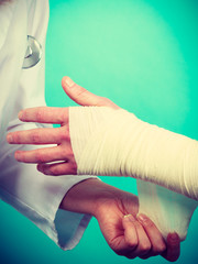 Doctor bandaging sprained wrist.