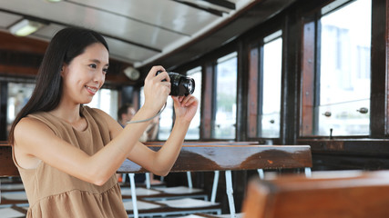Fototapeta na wymiar Traveler taking photo with digital camera on ferry in Hong Kong