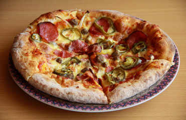 Pizza with topping Smoked Beef, Onion, Green Pepper, and Mozzarella Cheese. Wood background.