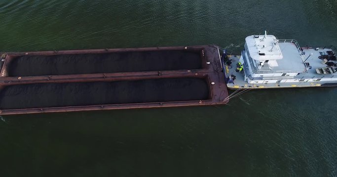 A top down aerial view of a coal barge traveling on the Ohio River.  	