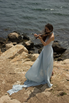 Girl playing violin at the beach in blue 5
