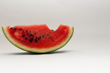 Slice of watermelon with a missing bite.