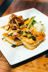 Grilled sea bass fish meat steak in white plate