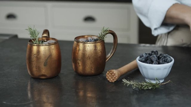 Chef places blueberries in Moscow mule