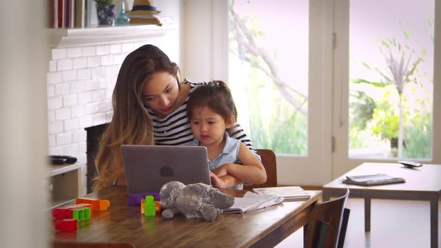 Mother And Daughter Watch Movie On Laptop At Home Together