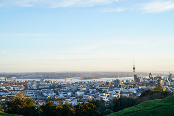 Fototapeta na wymiar Sky Tower and Auckland Harbour Bridge landmarks on city skyline from atop Mount Eden.
