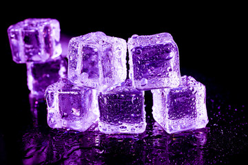 Purple ice cubes on a black table.