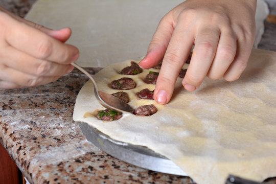Preparing, cooking, making homemade ravioli, pelmeni or dumplings with meat