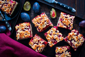 Cake with caramelized plums and scabbard, top view, horizontal