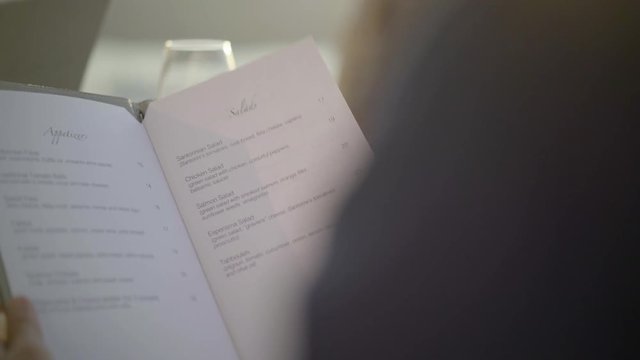 4k video closeup reading restaurant menu outdoors at dinner table