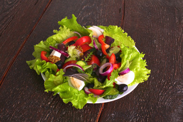 salad from fresh vegetables in a plate on a table, selective focus
