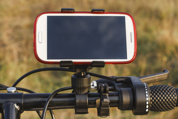 The mobile phone attached to the handlebars of the Bicycle. Technical devices for sport