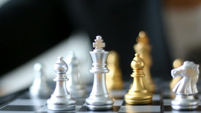 Close up shot hands of man and business woman moving gold chess  and  silver chess on chess board game for winner and loser business challenge metaphor and business competition concept