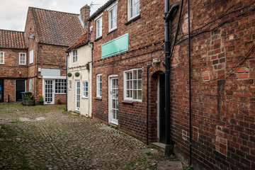 dark brick houses and cobblestones in the old city Thirsk, North Yorkshire, England, UK