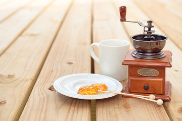 candy lollipop and coffee mill on wooden background